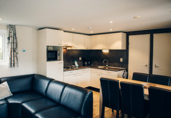 Helles Wohn- und Esszimmer mit moderner Küche in der Dune Lodge bei Duinhoeve, Niederlande.