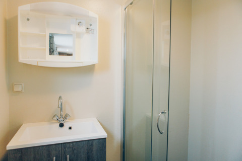 Bathroom at Dune Lodge in Duinhoeve, Netherlands, featuring a sink, mirror cabinet, and glass shower.