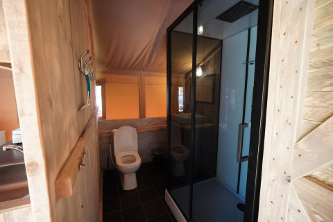 Badezimmer im Safari-Zelt auf Camping De Rammelbeek, Niederlande, mit Dusche und WC.