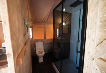 Badezimmer im Safari-Zelt auf Camping De Rammelbeek, Niederlande, mit Dusche und WC.
