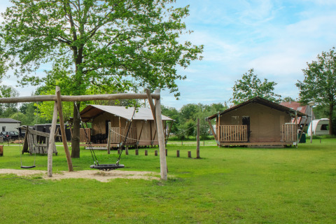 Safari-Zelt auf Camping De Rammelbeek in den Niederlanden, mit Spielplatz und grünen Wiesen im Freien.