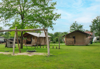 Safari-Zelt auf Camping De Rammelbeek in den Niederlanden, mit Spielplatz und grünen Wiesen im Freien.