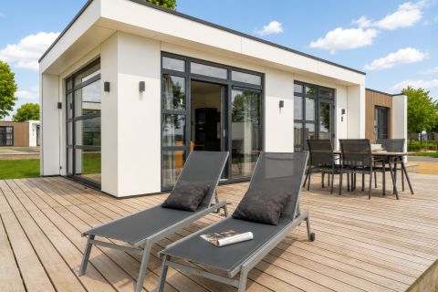 Zonnig terras met ligzetels en tafel bij Villa ‘Maritiem’ in MarinaPark Bad Nederrijn, Nederland.