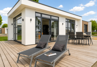 Zonnig terras met ligzetels en tafel bij Villa ‘Maritiem’ in MarinaPark Bad Nederrijn, Nederland.