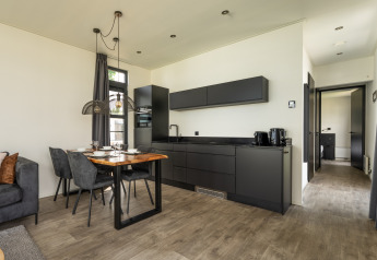 Moderne keuken met eetruimte in Villa «Maritiem», gelegen aan MarinaPark Bad Nederrijn, Nederland.