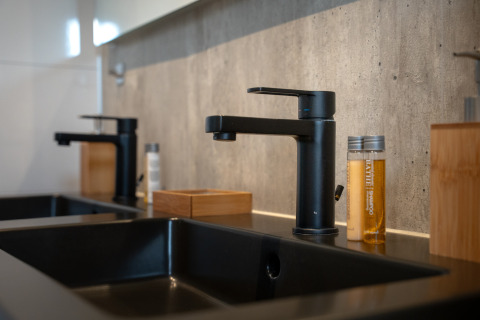 Moderne Doppelwaschbecken mit schwarzen Armaturen und Toilettenartikeln in der Villa Maritiem, MarinaPark Bad Nederrijn.
