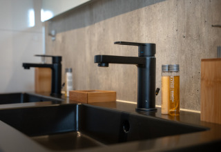 Moderne Doppelwaschbecken mit schwarzen Armaturen und Toilettenartikeln in der Villa Maritiem, MarinaPark Bad Nederrijn.