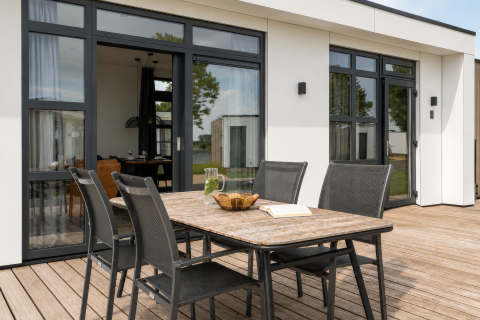 Terrasse mit Esstisch und vier Stühlen bei Villa Maritiem, MarinaPark Bad Nederrijn, Niederlande.