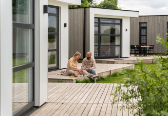 Koppel op het houten terras bij Villa Maritiem, MarinaPark Bad Nederrijn, moderne lodges in Nederland.