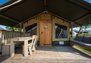 Safaritent ‘Compact’ op Camping de Molenhoek in Nederland met houten terras, tafel en comfortabele zitbank.