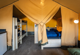 Interno della tenda safari 'Compact' con letti a castello e letto matrimoniale al Camping de Molenhoek, Paesi Bassi.