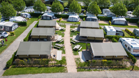 Vista aerea delle tende safari 'Compact' al Camping de Molenhoek nei Paesi Bassi, circondate da roulotte.