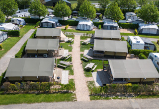 Luchtfoto van ‘Compact’ safaritenten op Camping de Molenhoek in Nederland, met caravans rondom.
