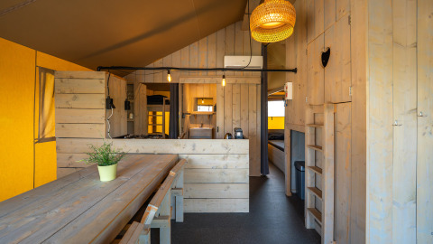 Interno della tenda safari 'Villatent Cottage' al Camping de Molenhoek nei Paesi Bassi con arredamento in legno.