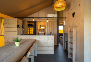 Interno della tenda safari 'Villatent Cottage' al Camping de Molenhoek nei Paesi Bassi con arredamento in legno.