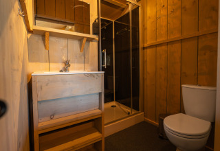Bagno moderno in una tenda safari, Villatent Cottage al Camping de Molenhoek, Paesi Bassi, con pareti in legno.