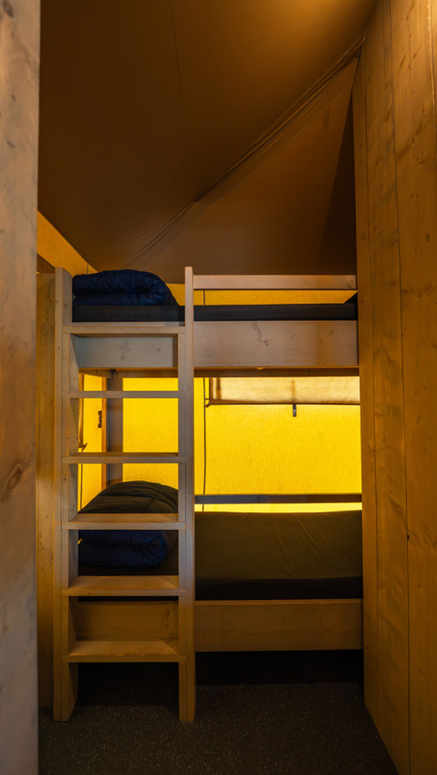 Letti a castello nella tenda safari Villatent Cottage al Camping de Molenhoek, Paesi Bassi, interno in legno.