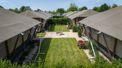 Tenda safari 'Villatent Cottage' al Camping de Molenhoek nei Paesi Bassi, con prato verde e sentieri.