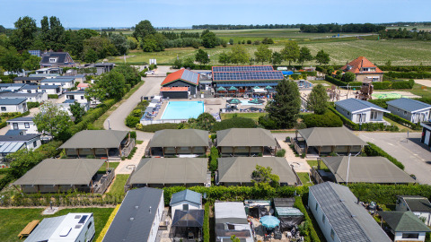 Vista aerea delle tende safari Villatent Cottage e della piscina al Camping de Molenhoek nei Paesi Bassi.