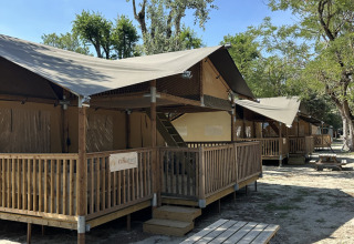 Safaritent ‘Ranger’ op Camping Spina Family Collection in Italië met houten terras en picknicktafel buiten.