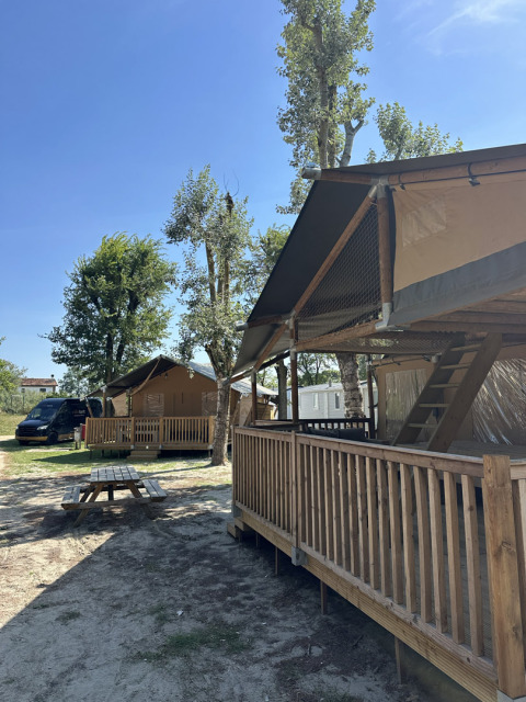 Tenda safari Ranger con veranda in legno al Camping Spina Family Collection in Italia, in una giornata di sole.