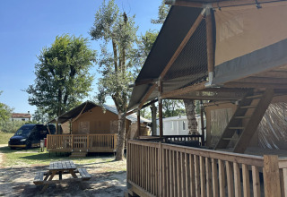 Safaritent Ranger met houten terras bij Camping Spina Family Collection in Italië onder blauwe lucht.