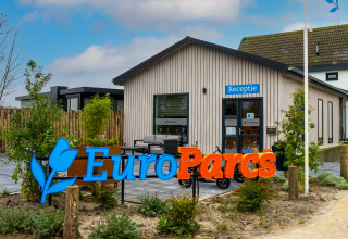 EuroParcs lodge reception building with blue Receptie sign, modern exterior, and landscaping in front.