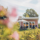 Valleichalet tiny house at Holiday park Ackersate in the Netherlands, surrounded by greenery and flowers.