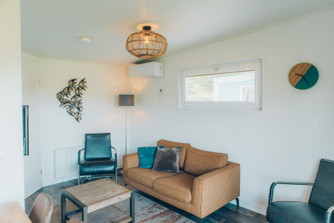 Woonkamer in de Valleichalet tiny house op Vakantiepark Ackersate, Nederland, met moderne inrichting.