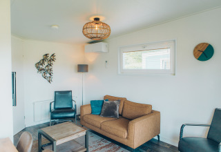 Living room inside Valleichalet tiny house at Holiday park Ackersate, Netherlands, featuring modern decor.