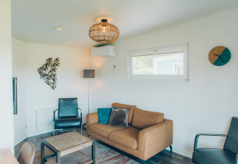 Soggiorno nella tiny house Valleichalet al Holiday park Ackersate, Paesi Bassi, con arredamento moderno.