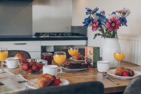 Et hyggeligt morgenbord med juice, croissanter, jordbær og blomster, taget i Valleichalet, Ackersate, Holland.