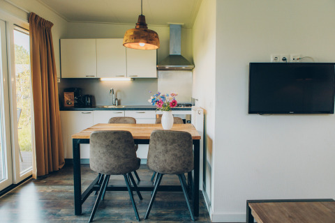 Bright, modern kitchen and dining area in the Valleichalet tiny house at Holiday park Ackersate, Netherlands.