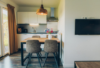 Bright, modern kitchen and dining area in the Valleichalet tiny house at Holiday park Ackersate, Netherlands.