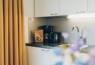 Keukenblok in het tiny house Valleichalet op vakantiepark Ackersate, Nederland, met koffiezetapparaat en wasbak.