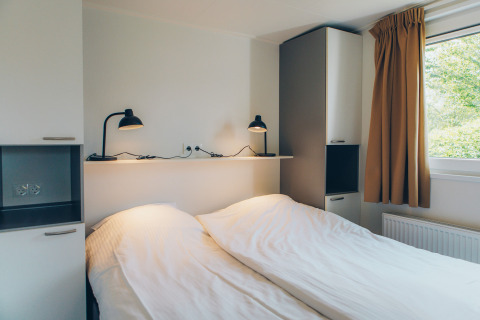 Bedroom at the Valleichalet tiny house in Holiday park Ackersate, Netherlands, with twin beds and modern decor.