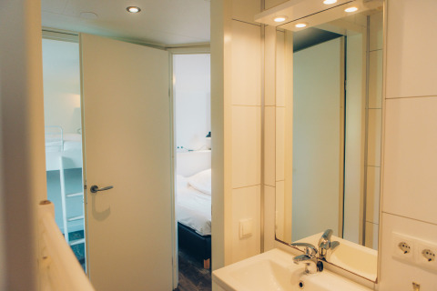 View from the bathroom to the bedroom in a tiny house named Valleichalet at Holiday park Ackersate, Netherlands.