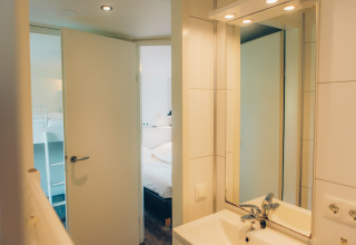 Vista desde el baño hacia el dormitorio en una tiny house llamada Valleichalet en Holiday park Ackersate, Países Bajos.