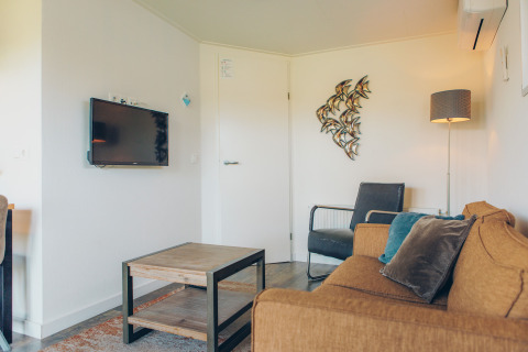 Modern living room inside Valleichalet tiny house at Holiday park Ackersate, Netherlands, with cozy decor.