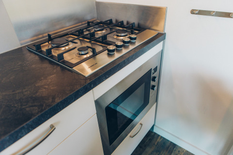 Modern gas stove and built-in oven in a tiny house at Valleichalet, Holiday park Ackersate, Netherlands.