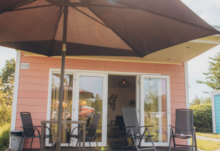 Outdoor area of the Valleichalet tiny house at Holiday park Ackersate, Netherlands, featuring patio and furniture.