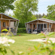 To safaritelt på Camping 't Veld i Holland, omgivet af grønne træer og en åben græsplæne.