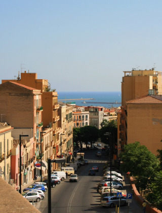Vista de calles y edificios en Vignole Mare, Cerdeña, Italia, con el mar al fondo en un día soleado.
