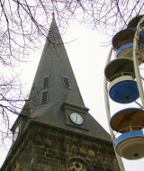 Torre de iglesia y noria juntos en Denekamp, Overijssel, Países Bajos, durante un día nublado de invierno.