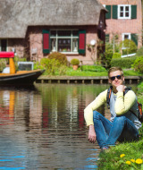 Mann sitzt am Ufer in Giethoorn, Overijssel, Niederlande