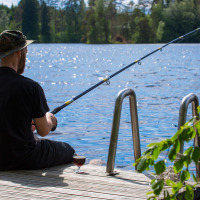 Hombre sentado pescando en un muelle