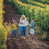 Moeder rent met zoontje en dochter door wijngaard