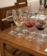 Copas con vino tinto, rosado y blanco sobre mesa de madera, cata de vinos