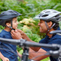 Vader helpt zoontje met fietshelm - Vodatent - Camping la Cour d_Enchère - Saint-Palais - Auvergne-Rhone-Alpes - Frankrijk