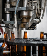 Máquina que sella botellas de cerveza en cervecería